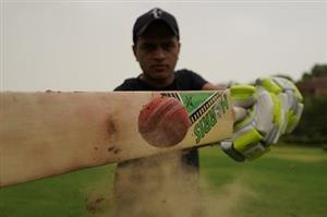 Serious man swinging cricket bat